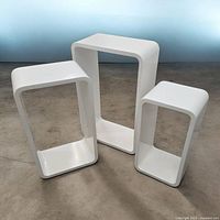 All three white glossy nesting tables standing side by side