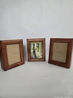 Front view of three wooden photo boxes displaying frame fronts