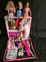 Overall lot showing wardrobe, dolls seated, clothing spread