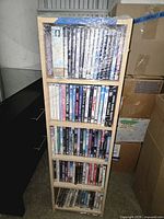 Full view of wooden 5-shelf tower filled with DVDs