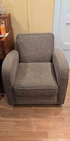 Front view of grey upholstered armchair