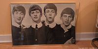 Front view of Beatles poster print in broken frame