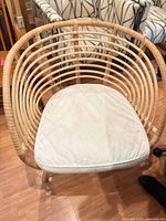 Front view of rattan armchair with white cushion