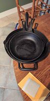 Top view of three nested cast iron skillets showing sizes and handles