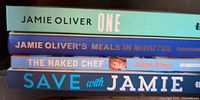 Stack of four Jamie Oliver cookbooks showing spines