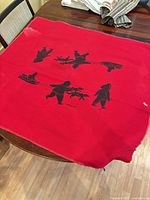 Full view of red woven wall hanging with Inuit silhouette design