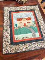 Full view of quilt showing house scene and borders