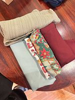 Four folded tablecloths showing colours and patterns