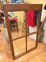 Front view of wooden windowpane mirror showing four mirrored panes