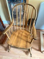 Overall view of wooden spindle-back rocking chair, showing seat, arms, back spindles and rockers
