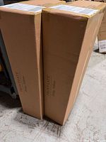 Two sealed Frontgate Holiday Collection cartons standing upright