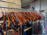 Row of dark wooden hangers on a metal rod, showing overall quantity and finish