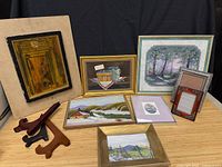 Group shot of all framed art, empty frame and easel stands