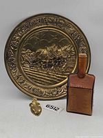 Lot overview showing brass wall plate, amber cabin bottle, brass holly clip