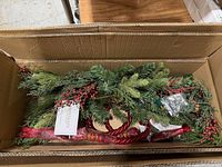 Both swags inside original carton showing foliage, berries and ribbon