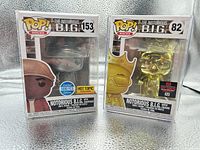 Front view of both boxed figures showing box art, numbers 153 and 82, exclusive stickers