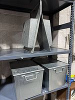 Two lidded bins and caddy on shelving