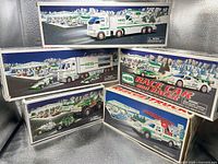 Front view of five Hess toy truck boxes showing graphics and years