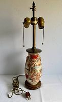 Full view of lamp showing sockets, cord, wood base and Satsuma vase body