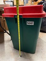 Side view of green bin with measuring tape showing height
