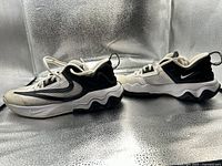 Side view of both shoes showing swoosh logos and wavy midsole design
