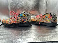 Lateral view of both shoes showing multicolor swirl upper and pink laces