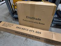 Unopened EliteShade patio umbrella base box and long umbrella box