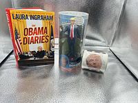 Group shot showing book, packaged Trump figure, and toilet paper roll