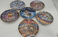 Six plates laid out showing all illustrated scenes and gold rims