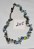 Full view of necklace with varied green and blue crystals and extender chain