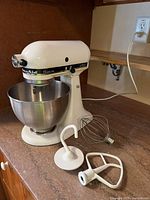 Mixer with bowl and three attachments displayed