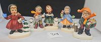Front view of all five Napcoware Christmas children figurines