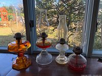 All four glass oil lamps lined up on window sill