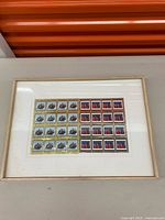 Front view of framed Canadian stamp sheets showing both panes clearly