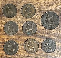 Eight bronze coins laid out on wooden surface