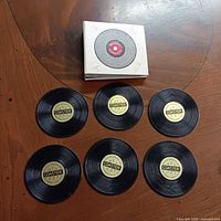 Complete set of six record coasters arranged beside holder