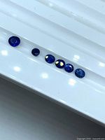 Six oval blue sapphire gemstones lined up