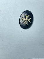 Front view of oval onyx gemstone showing Maltese star motif