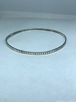 Full view of circular bangle lying flat