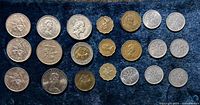 Overall view of 21 Hong Kong and Japanese coins laid out on dark fabric