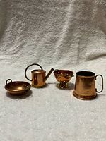 all four miniature copper utensils displayed