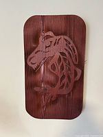 Front view of cedar-stained plaque showing full sea monster carving