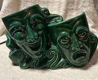 Front view of green ceramic lamp with comedy and tragedy faces