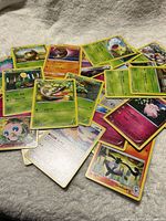 Pile of assorted Pokémon cards showing mix of Grass, Psychic and Fairy types