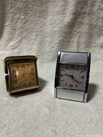 Westclox and Alpine travel alarm clocks side by side