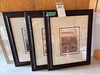 Three of the four framed prints leaning against counter