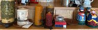 Wide shot of shelf showing all candles, holders, figurine candleholders, boxed tealights