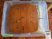Front view of square wooden mechanical wall clock with chain