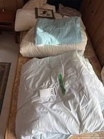 Comforters and folded bedding on mattress