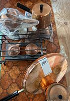 Overview of copper pots, warming racks, fuel cups, large lid